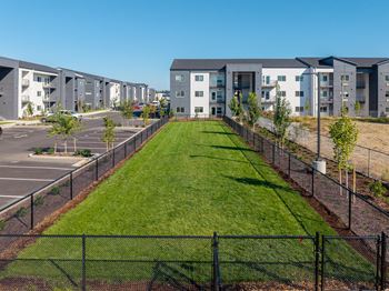 A row of modern apartment buildings with a green lawn in the foreground.